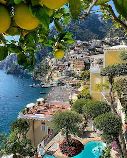 Colorful buildings of Positano Italy on a cliff above the sea framed by lemon tree branches