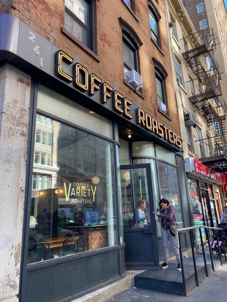 Exterior of a Coffee Roasters café with neon sign and large windows on a city street