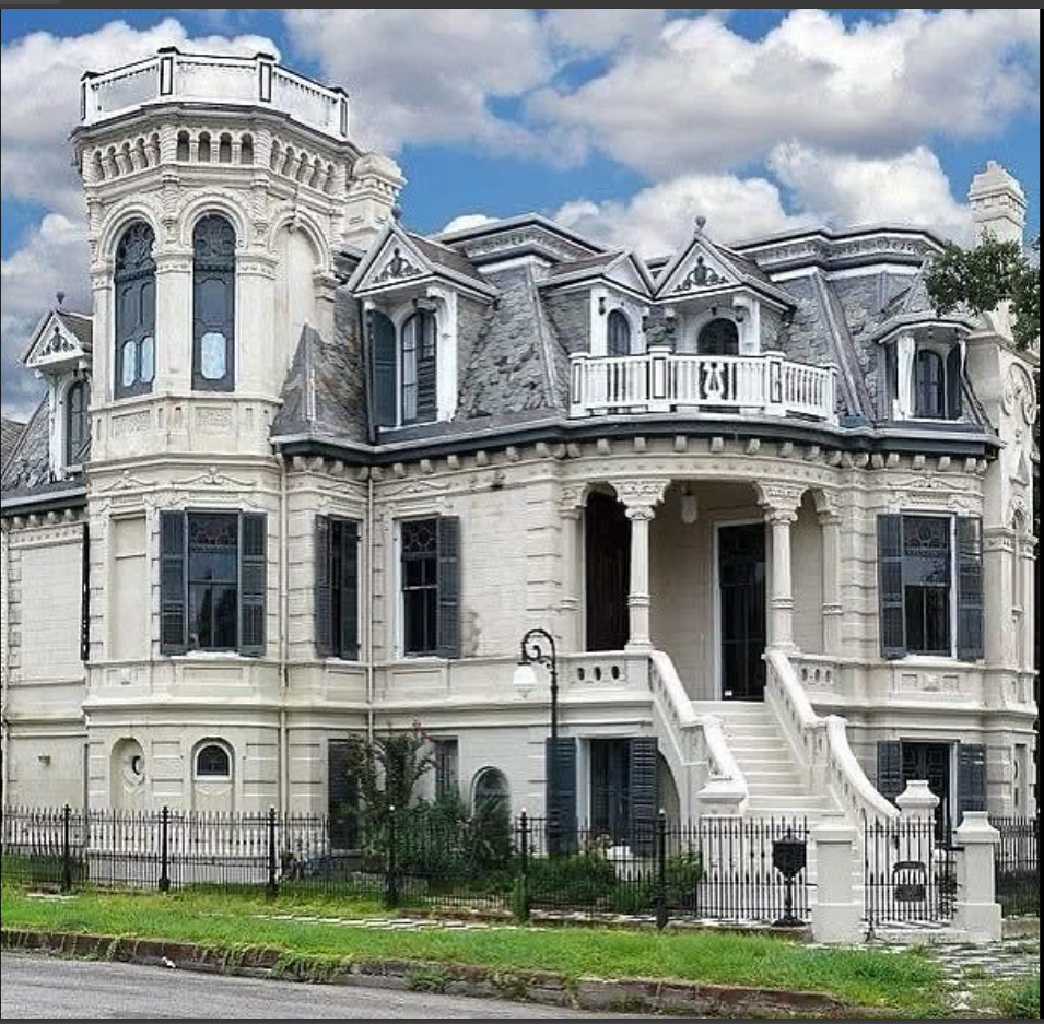 Large ornate white Victorian mansion with curved tower, balconies, columns and baroque architectural details