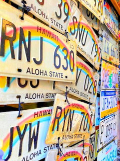 Overlapping Hawaii license plates with rainbow colored text and Aloha State branding