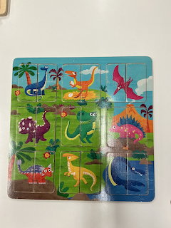 Colorful cartoon dinosaur puzzle board with several dinosaurs on a bright background