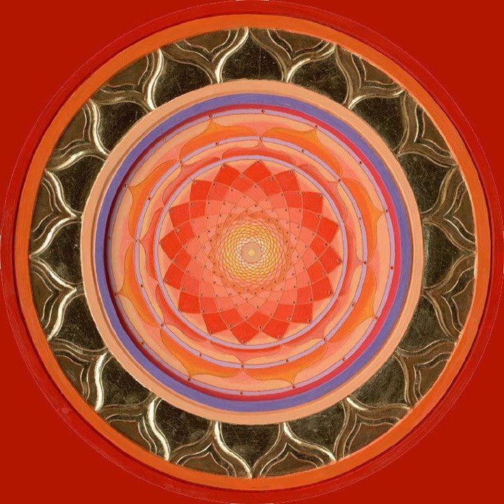 Circular mandala with lotus pattern and concentric geometric rings in orange, pink, and gold on red background