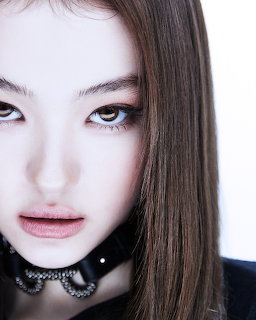 Close-up portrait of a young woman with brown hair wearing a black choker necklace