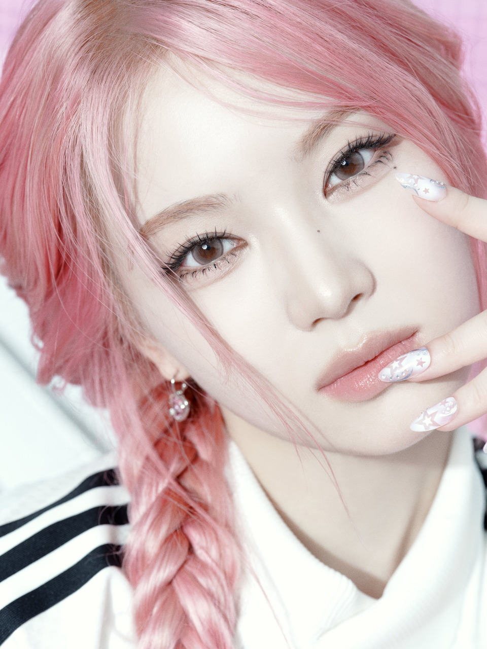 Portrait of woman with pink braided hair and striped collar shirt looking at camera
