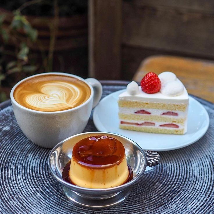 Latte art with a slice of strawberry shortcake and caramel flan on a table