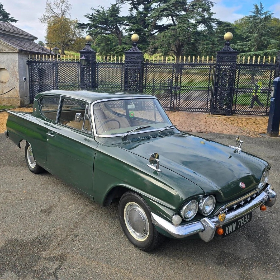 Vintage dark green Ford Consul Classic 315 parked by iron gates