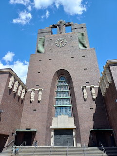 Front facade of the former Holy Cross Church in Gelsenkirchen, red brick modernist architecture with clock tower and stained glass
