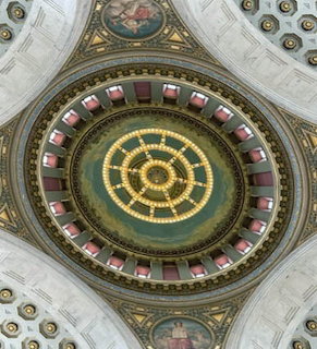 Looking up at the interior of the Rhode Island State House dome with chandelier and ornate decorations