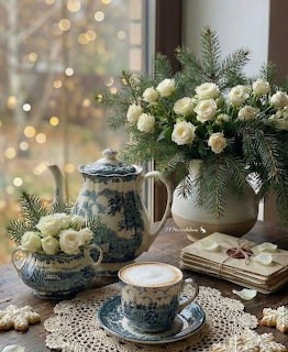 Vintage blue floral tea set with white roses and evergreen branches on lace doily