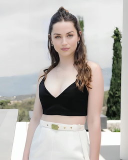 Young woman standing outdoors in a black crop top and white high-waisted bottoms