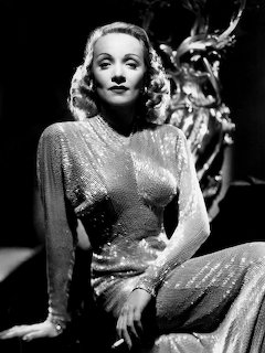 Black and white portrait of Marlene Dietrich in a shimmering sequined dress, seated pose