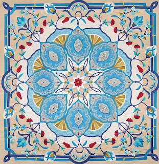 Detailed quilt with blue mandala center, paisley designs, and colorful floral border on white fabric