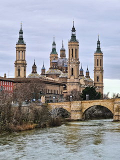 Basilica del Pilar with ornate towers and bridge over river in Zaragoza