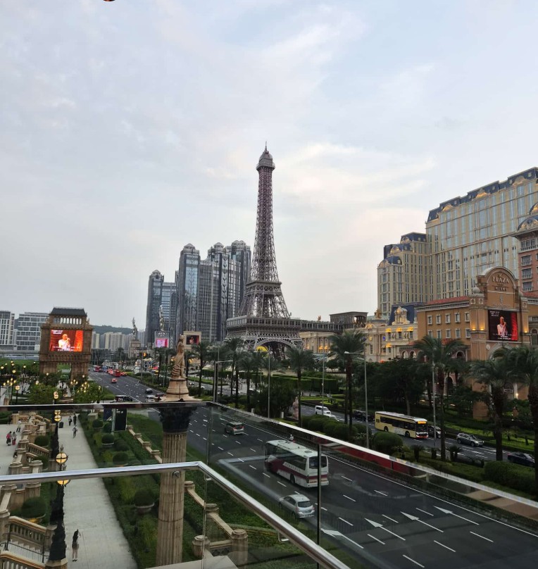 Macau city view with Eiffel Tower replica, casino buildings, and traffic on urban street