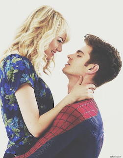 Young blonde woman and man in Spider-Man costume in a close romantic embrace