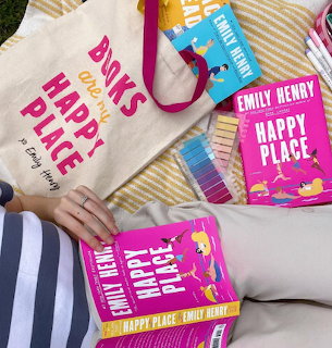 Colorful books and a canvas tote bag on a yellow striped blanket