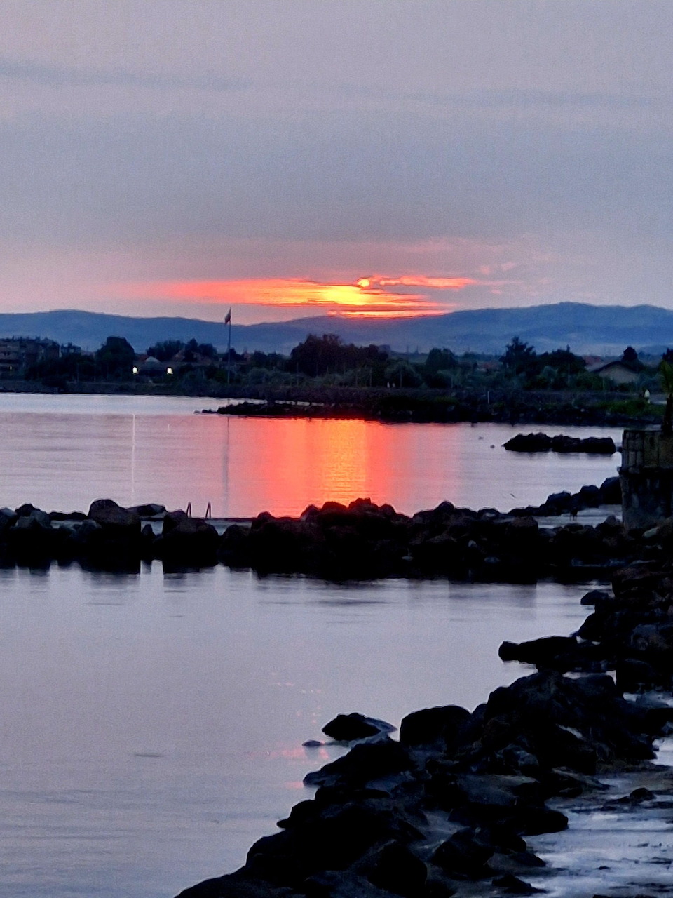 Sunset over the sea at Pomorie, Bulgaria with golden sky reflecting on calm water