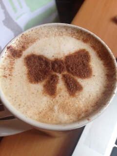Cup of latte with cocoa bow latte art seen from above