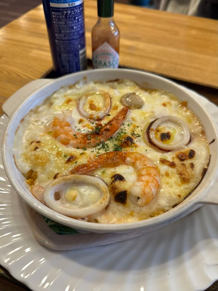 Baked seafood doria with shrimp, squid, and melted cheese in ceramic dish