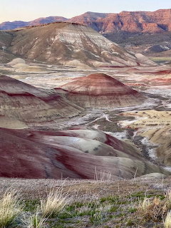 Colorful layered hills at the Painted Hills in Oregon with dry grass in the foreground