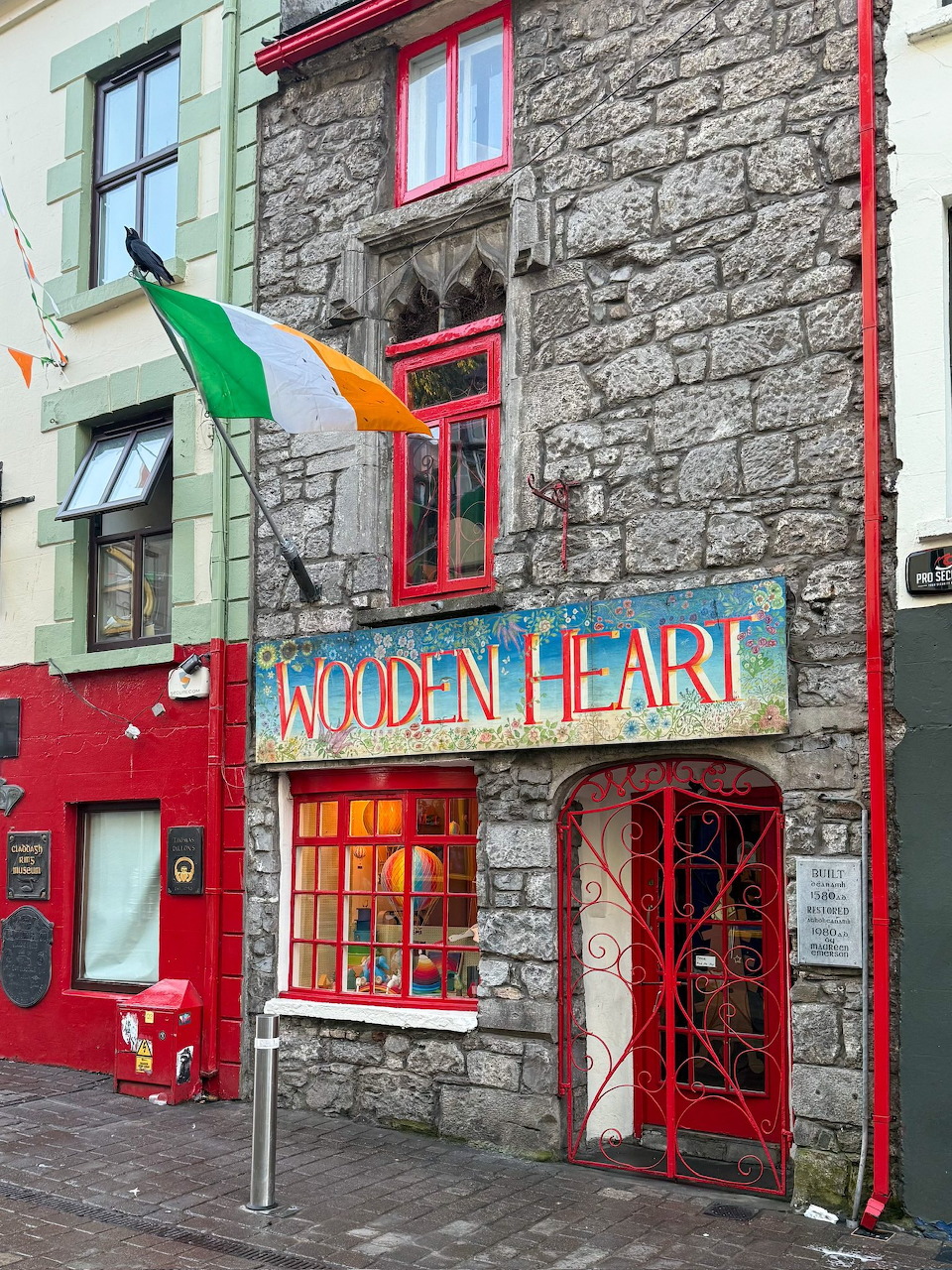 Stone pub building with red window frames and Golden Heart sign in Galway, Ireland