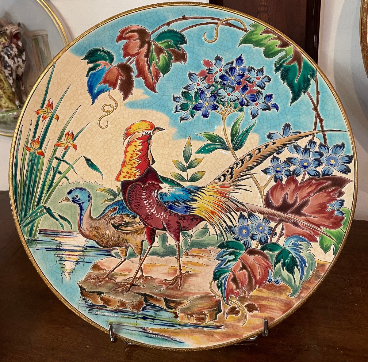 Round decorative plate with painted birds, flowers, and reeds