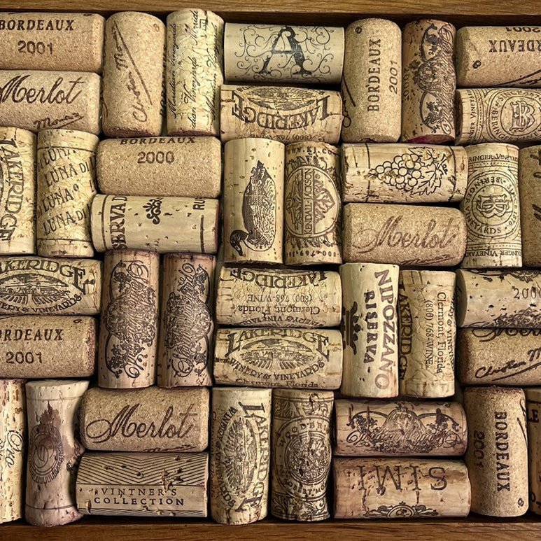 Arrangement of used wine corks showing text, dates, and winery stamps