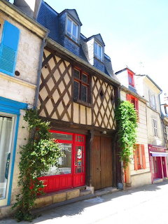 Half-timbered medieval house with red door on a narrow coblestone street in Bourges, France