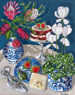 Still life painting with figs, protea flowers in blue vase, white orchids, and decorative plates on table