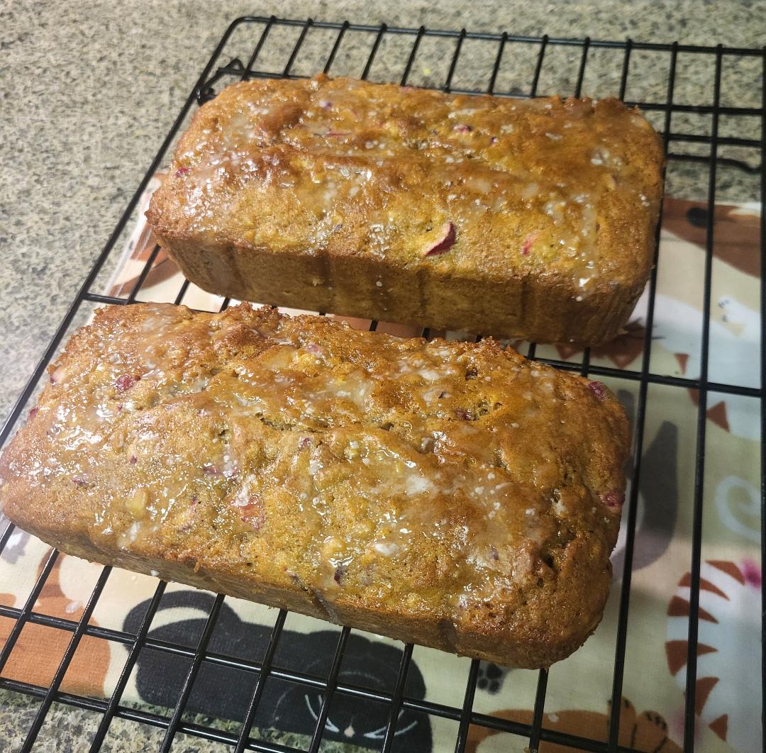Two loaves of cranberry bread cooling on a wire rack
