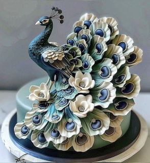 Peacock-shaped decorative cake with blue and white feather details and white sugar flowers