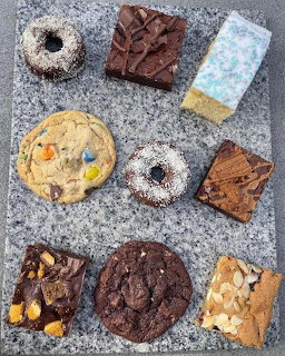 Assorted cookies, brownies, and desserts on granite countertop from above