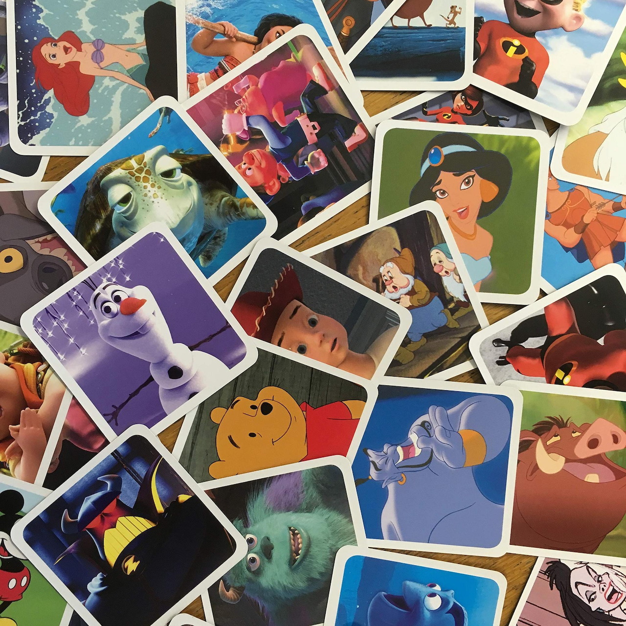 Overlapping collage of colorful Disney character illustration cards on white background
