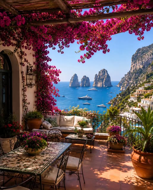 Coastal terrace with bougainvillea overlooking blue sea and rock formations through archway