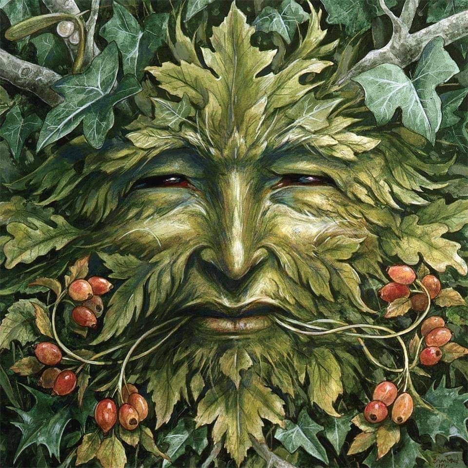 Green Man face made of leaves surrounded by ivy and red berries