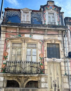 Colorful Art Nouveau building facade with floral tile work, balcony, and ornate stonework details