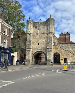 Bootham Bar stone gatehouse with arched entrance beside a street and brick buildings