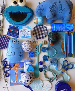 Flat lay of many blue items, including plush toys, pens, beads, containers, and small accessories