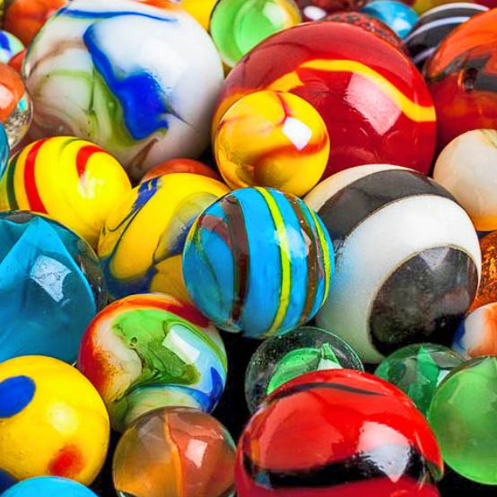 Close-up view of colorful glass marbles with swirled patterns and stripes in red, yellow, blue, green, and white
