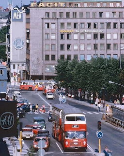 1970s Stockholm street with red double-decker bus, cars, and pedestrians on Hamngatan