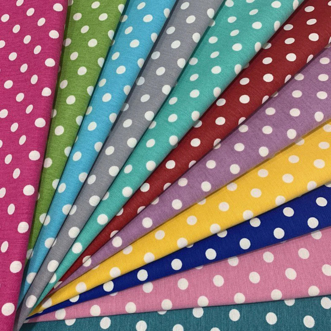 Colorful fabric strips with white polka dots fanned out diagonally