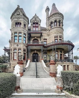 Ornate Victorian stone mansion with multiple turrets and grand entrance staircase
