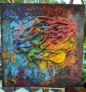 Abstract textured painting of a brain in rainbow colors on canvas