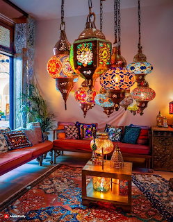 Colorful Moroccan glass lanterns hanging in a cozy bohemian-style living room with red sofa and patterned rug