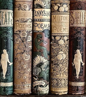 Row of ornate vintage poetry book spines with gold decorative patterns and classical figures