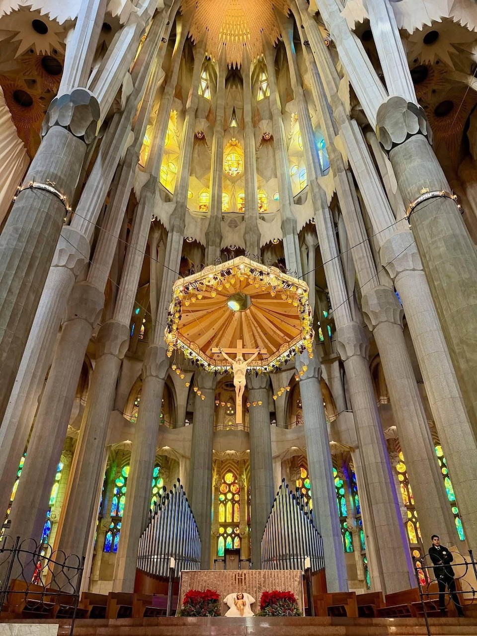Altar beneath a golden canopy inside La Sagrada Familia, surrounded by tall columns and stained glass