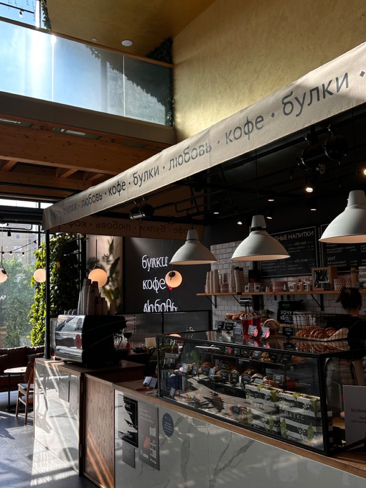 Modern cafe interior with bakery display counter, pendant lights, and natural light from windows