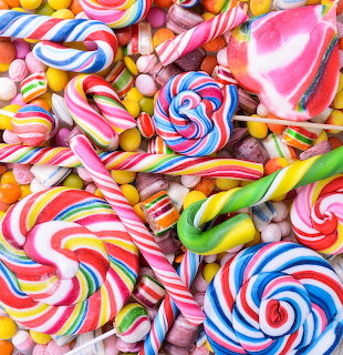 Assorted colorful spiral lollipops and striped candy canes arranged together
