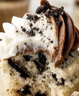 Close-up of a cupcake with swirled chocolate and vanilla frosting topped with cookie crumbs