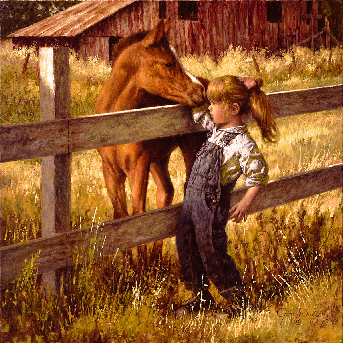 Young girl in overalls reaching toward brown horse over wooden fence near red barn